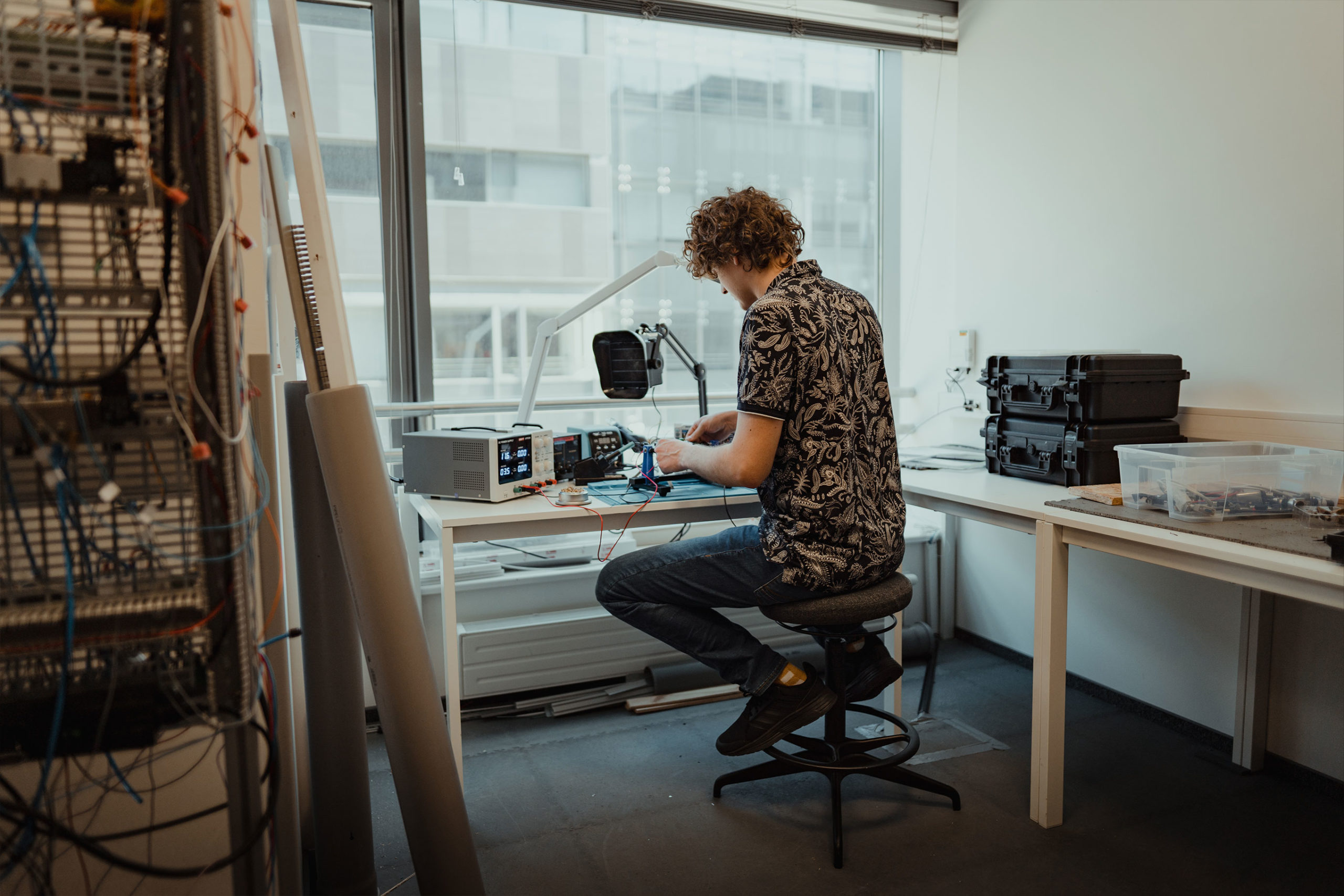 A person near a window, prototyping an electronic device