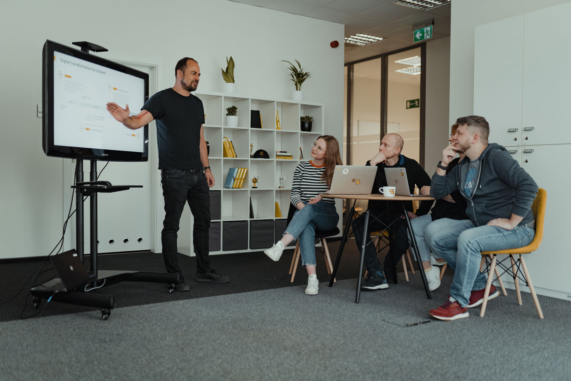 A person presenting a topic to a group of four people