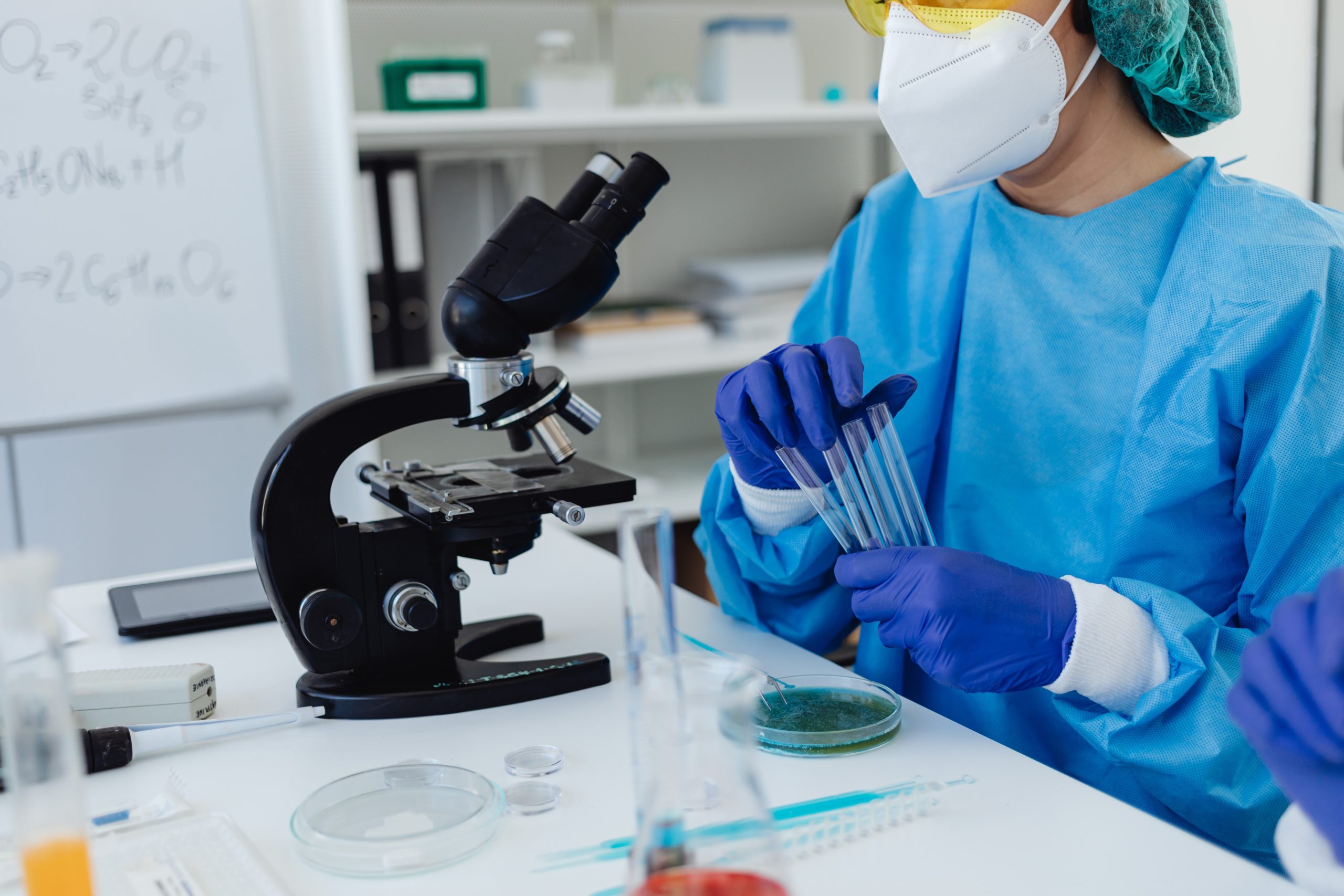 A scientist putting samples into a traditional microscope