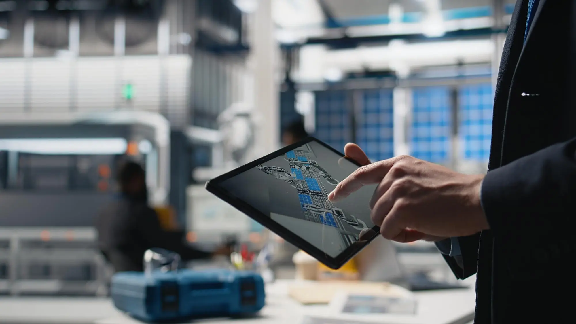 Systems engineer using a digital tablet to monitor integrated manufacturing data pipelines and unified industrial architecture.